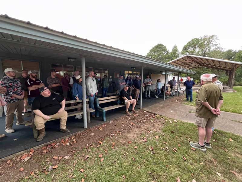 Group of people gathered under a building's covered porch.