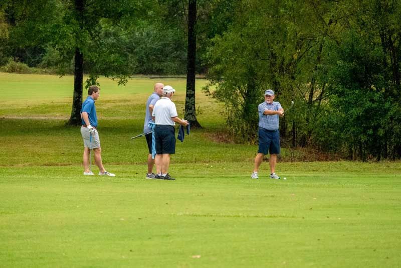 Four men on a golf course. 
