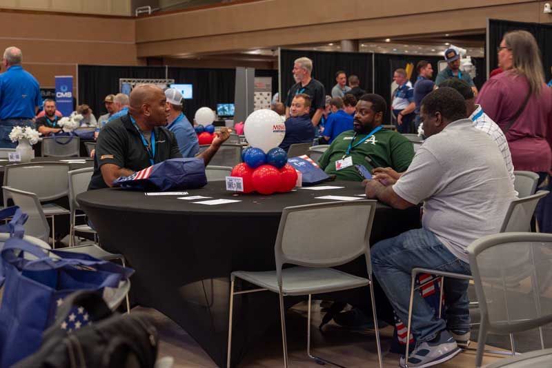 People seated at a round table, discussing. 