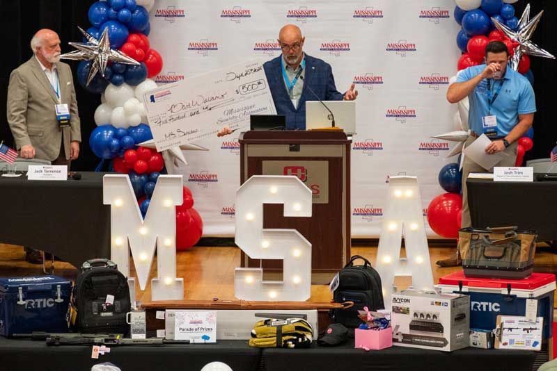Man holding large check at podium.