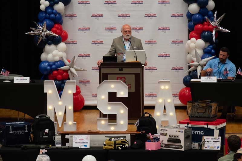 Man at podium speaks at event with 