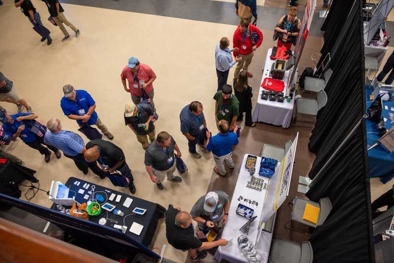 Overhead view of a trade show with people browsing vendor booths.