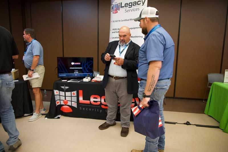 Two men at a trade show booth.