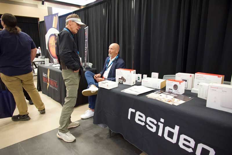 Two men conversing at a resideo booth.