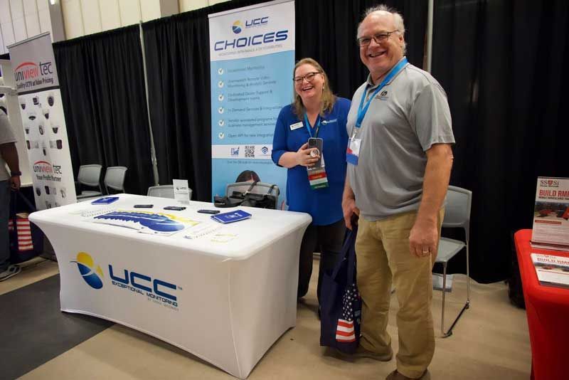 Two people at a booth at a conference. 