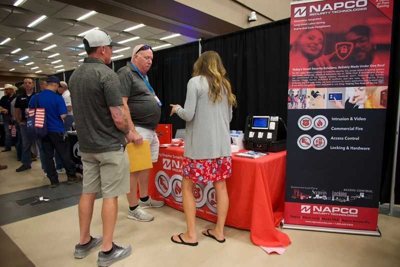 People at a trade show booth, discussing products. 