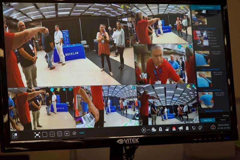 Monitor displaying multiple camera views of people in a large venue.