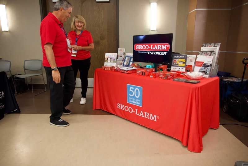 Two people in red shirts stand.
