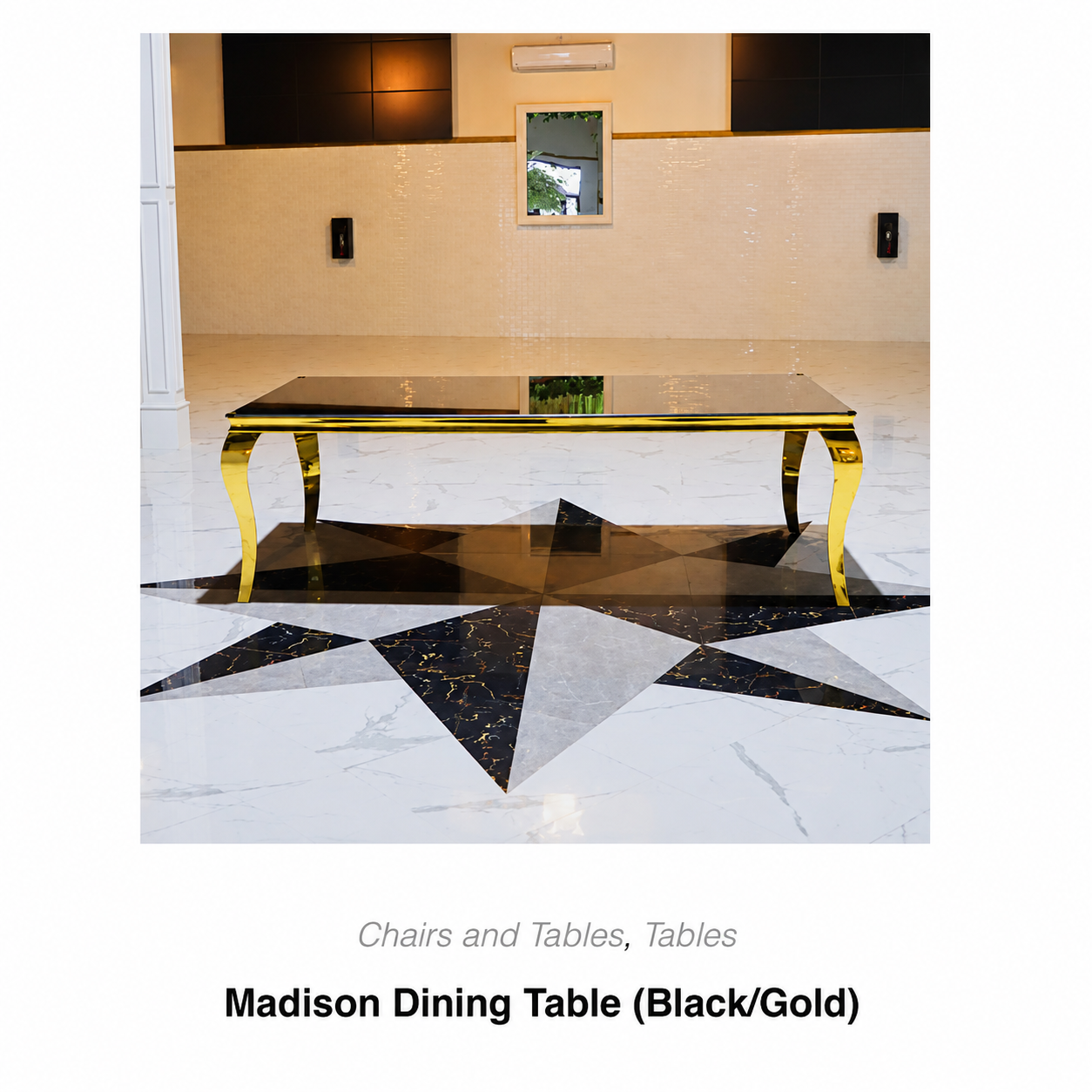 Black and gold dining table in a modern interior, shown on a geometric black-and-white floor.