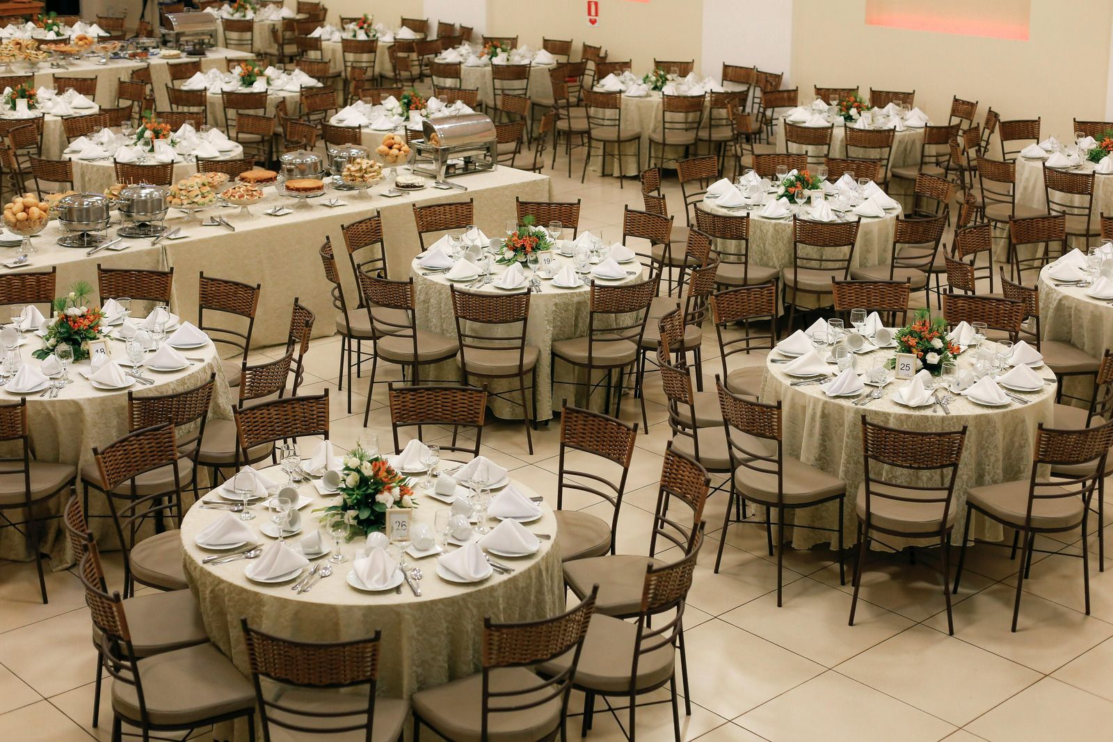 Banquet hall with round tables, white tablecloths, and chairs set for a formal event