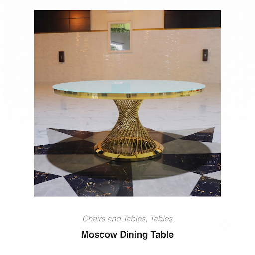 Moscow dining table with glass top and gold sculptural base in a showroom