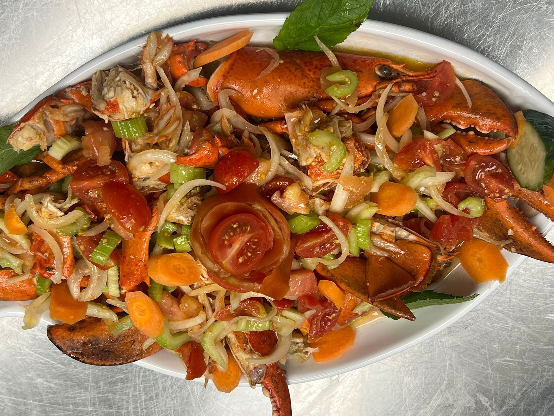 Piatto di chele di granchio cotte e verdure in una salsa saporita su un piatto bianco