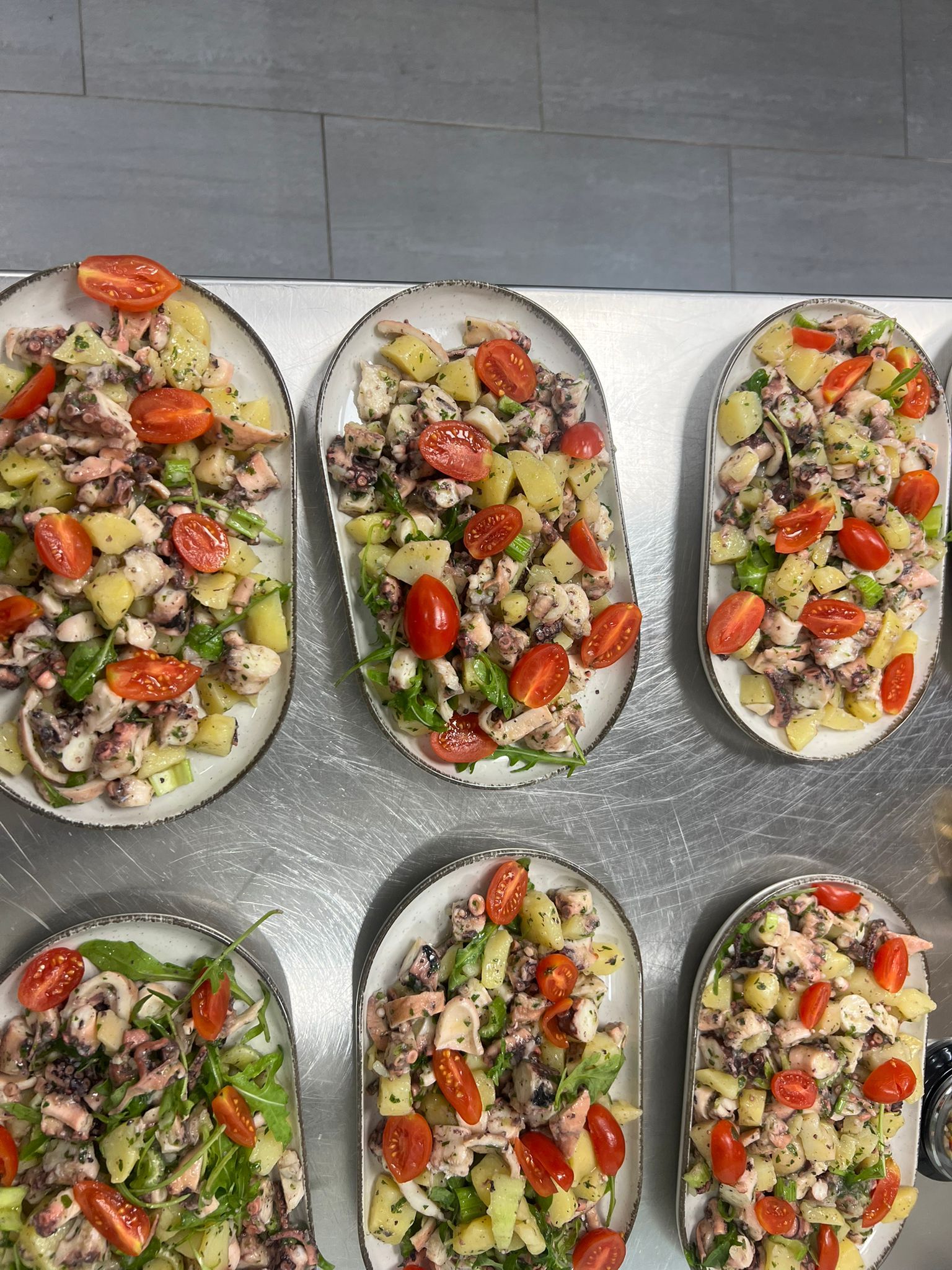 Melanzane ripiene al forno con verdure tritate, servite su un vassoio.