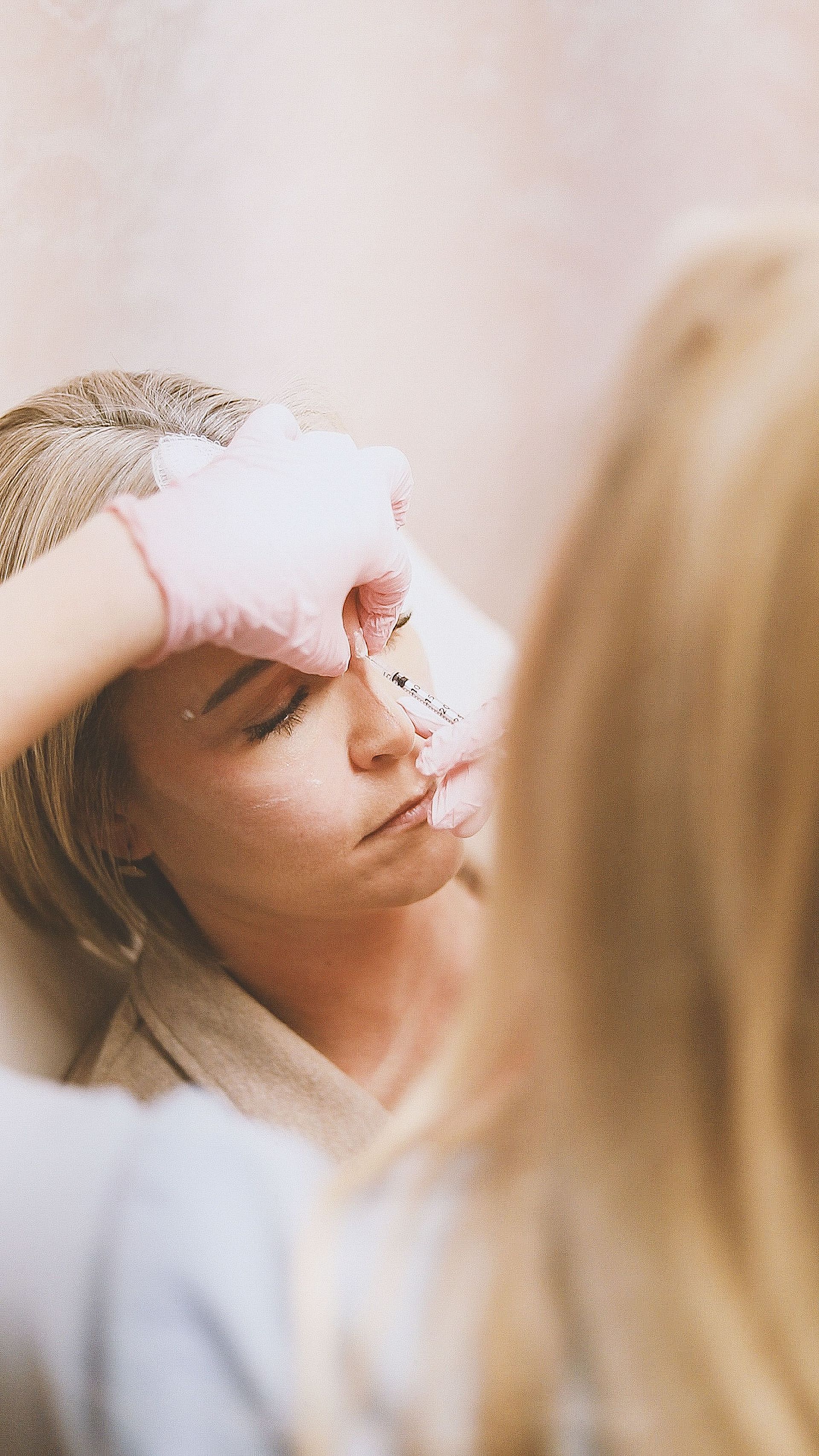 Person applying makeup while looking in a mirror.