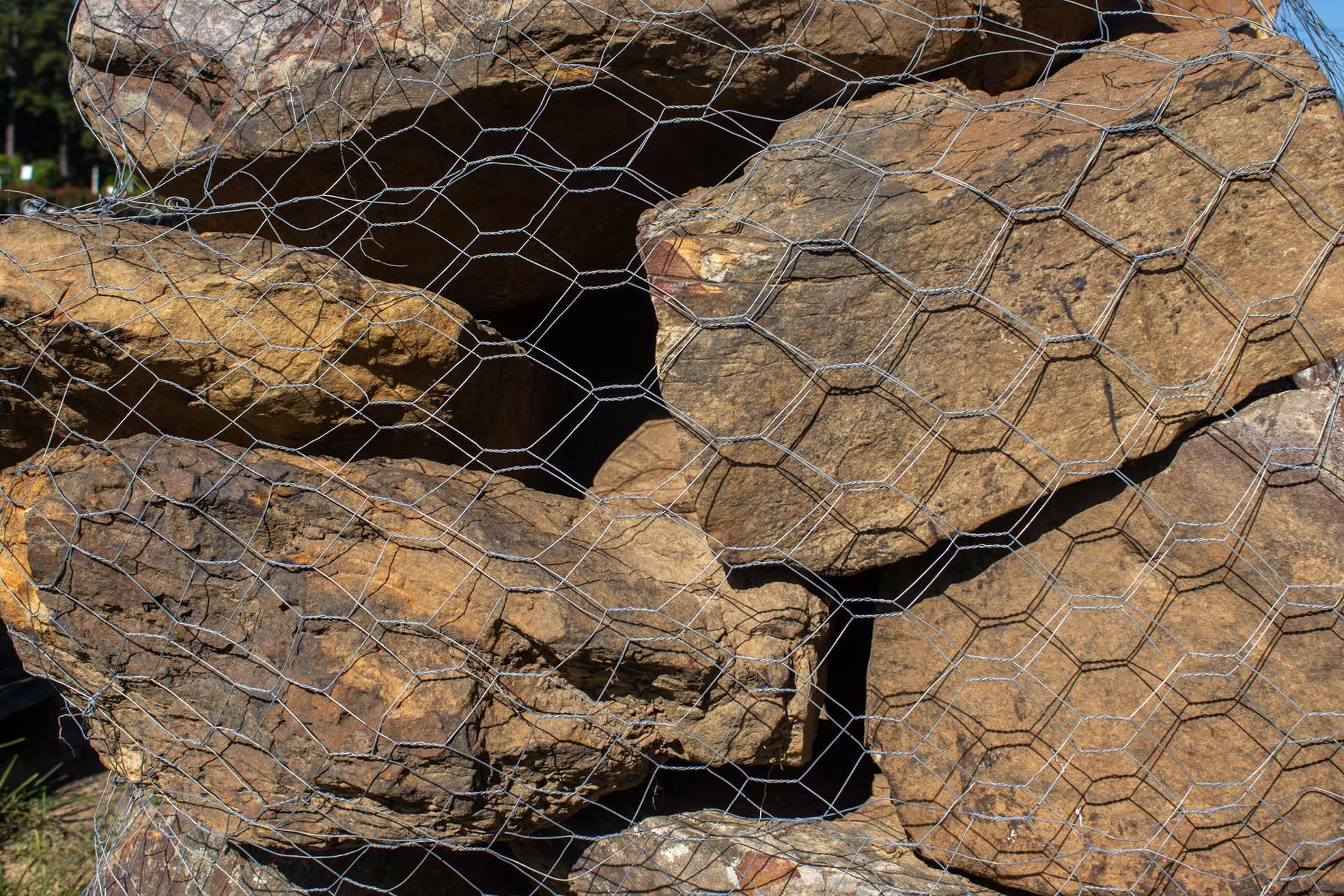 Rocky soil covered with wire mesh erosion control netting outdoors
