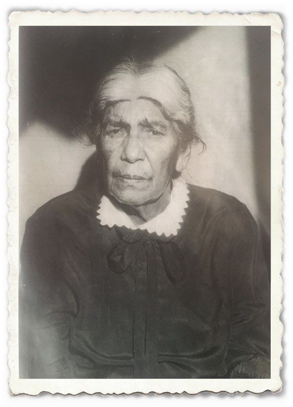 A black and white photo of an elderly woman in a black dress.