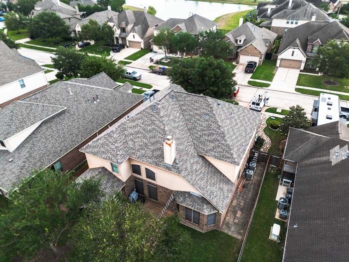 Aerial view of a suburban neighborhood with several houses, driveways, and trees.