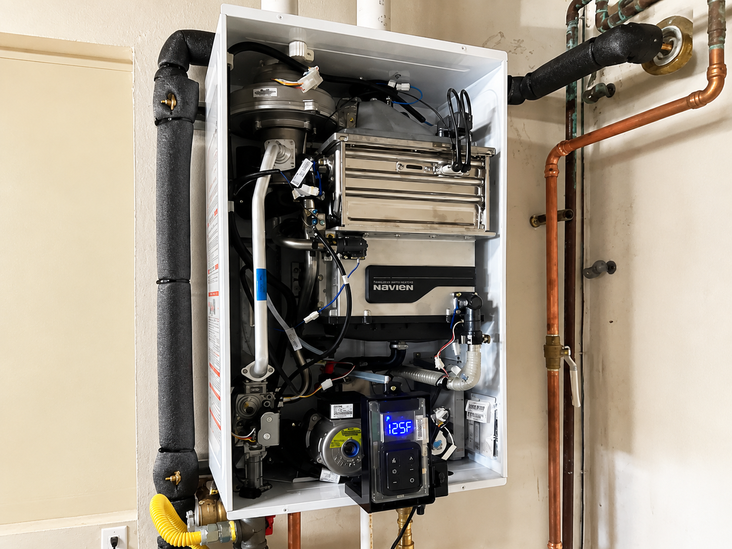 Wall-mounted boiler/furnace with exposed pipes and controls inside a utility closet