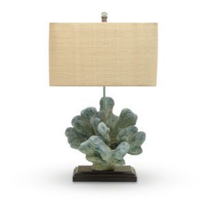 Beige table lamp with rectangular shade and turquoise coral-shaped base on a dark stand