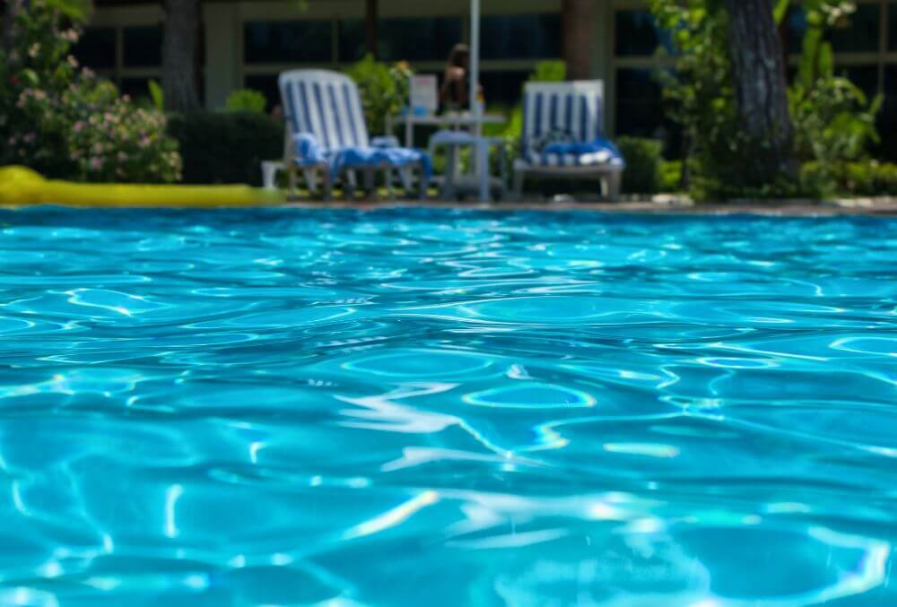 Crystal clear water in the pool with beach beds