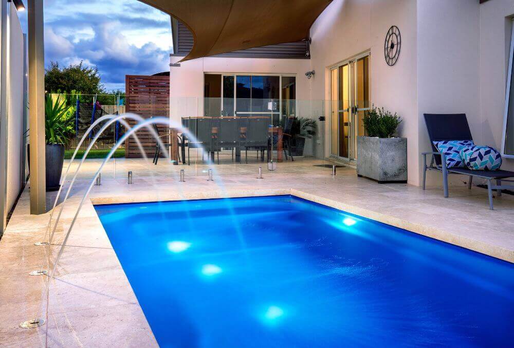Deck jets water feature beside a residential pool