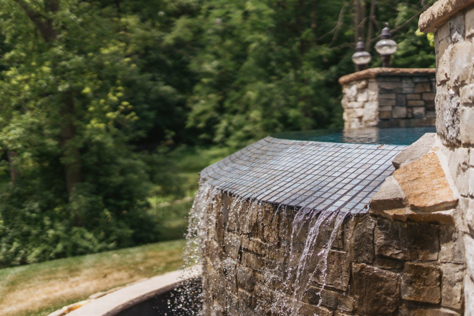 Slanting waterwall feature in a multi-leveled pool