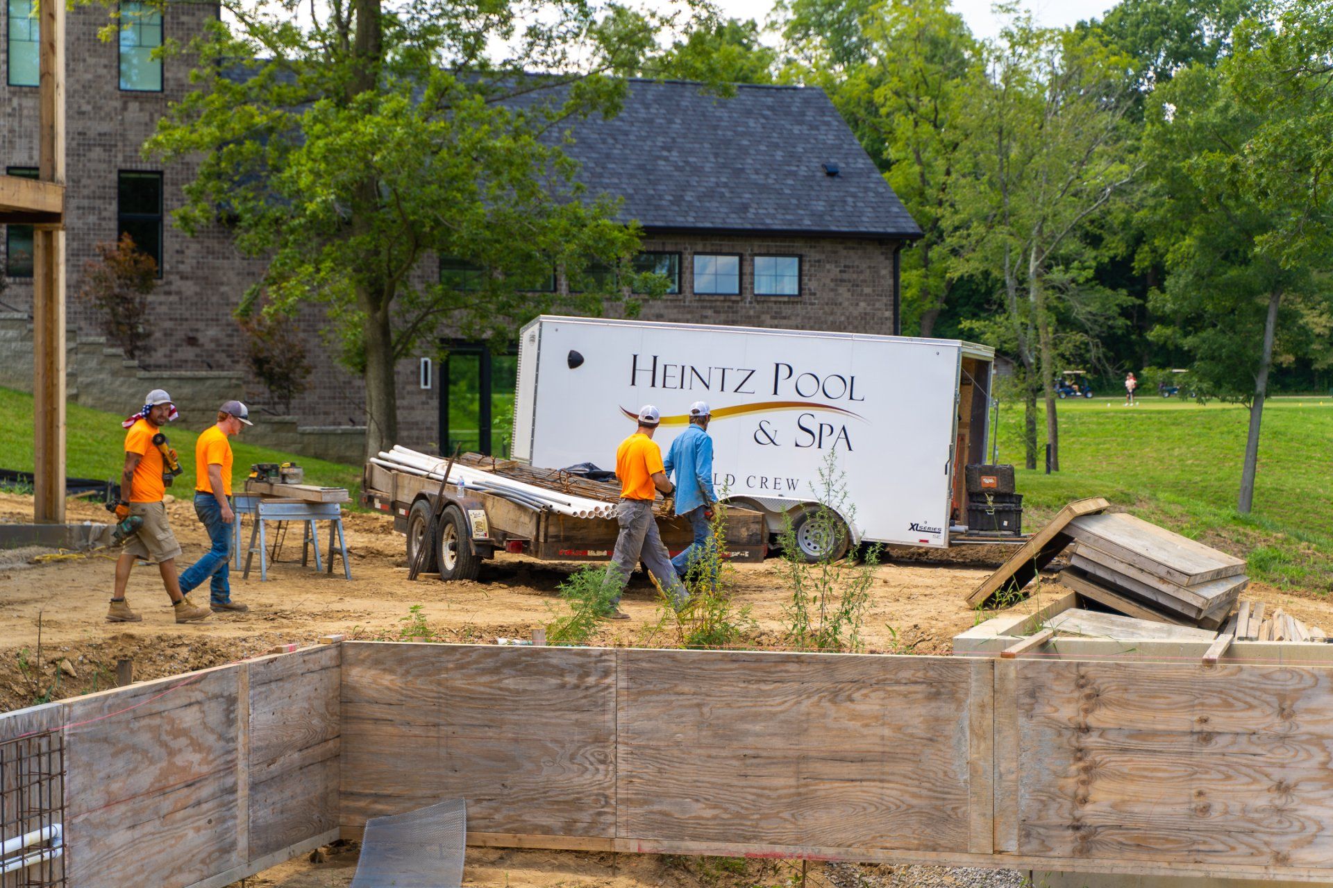 Four Heintz pool & Spa contractors walking beside a pool under remodeling