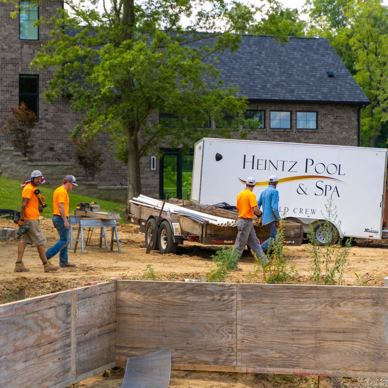 Team of pool and spa builder walking beside a pool under construction