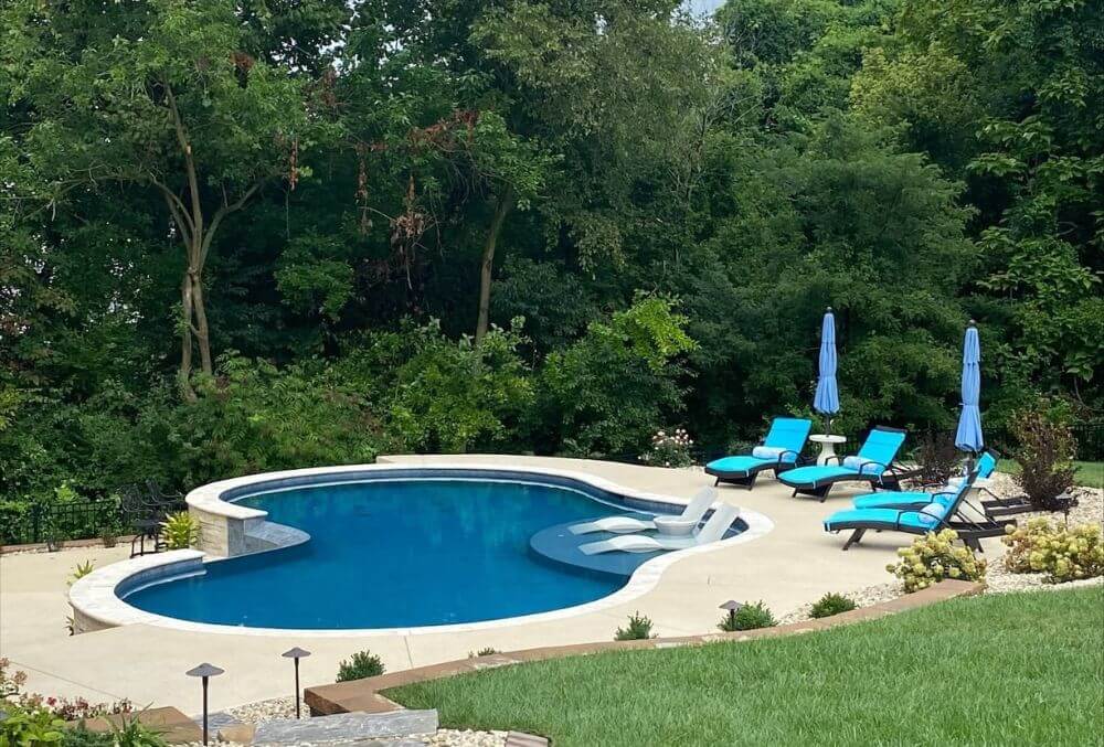Kidney shaped pool with beach beds around it