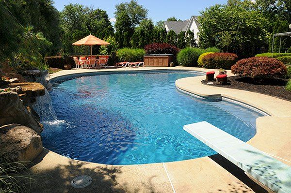 Bean shaped pool with waterfalls and diving board