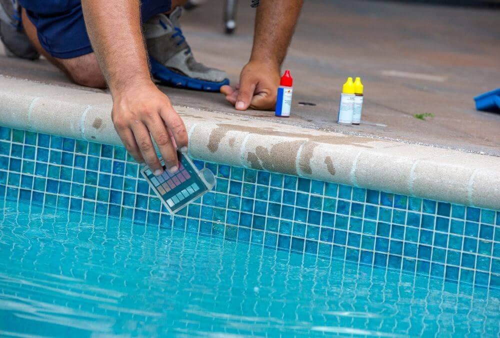 Pool testing kit being used in a swimming pool