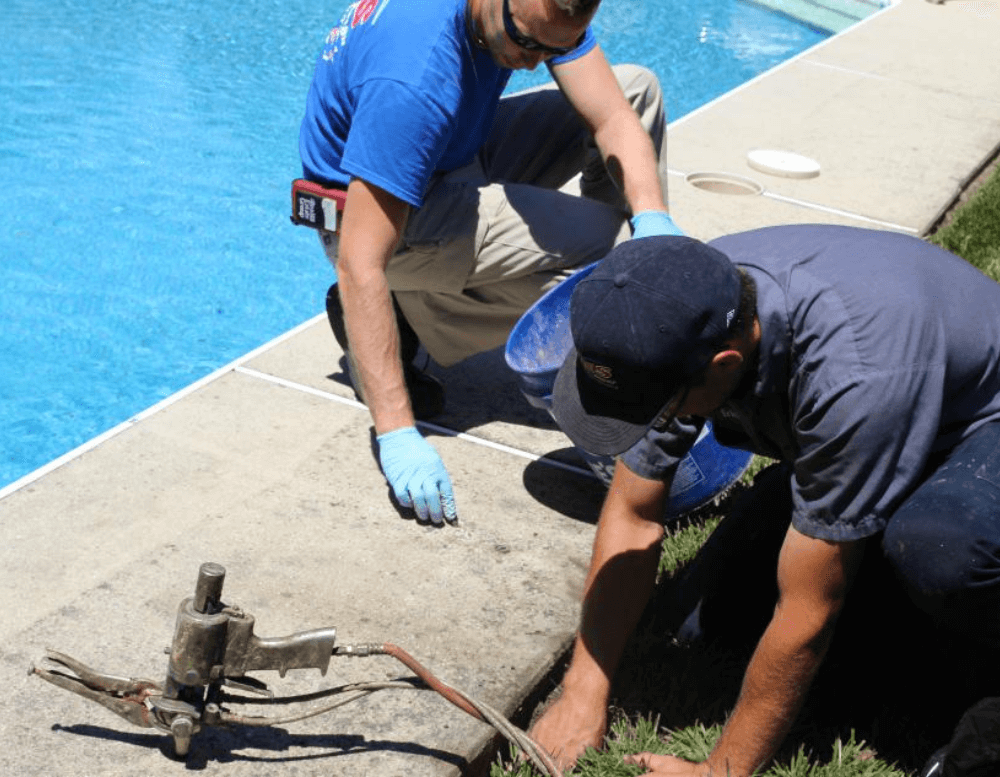 men working on repairing the  pool deck