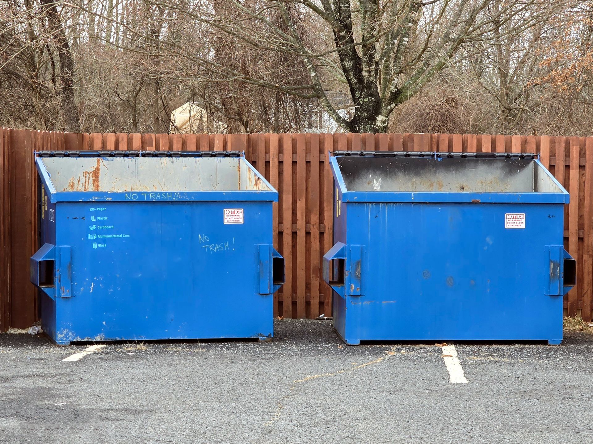 Two waste management blue garbage dumpsters used for commercial and residential garbage.