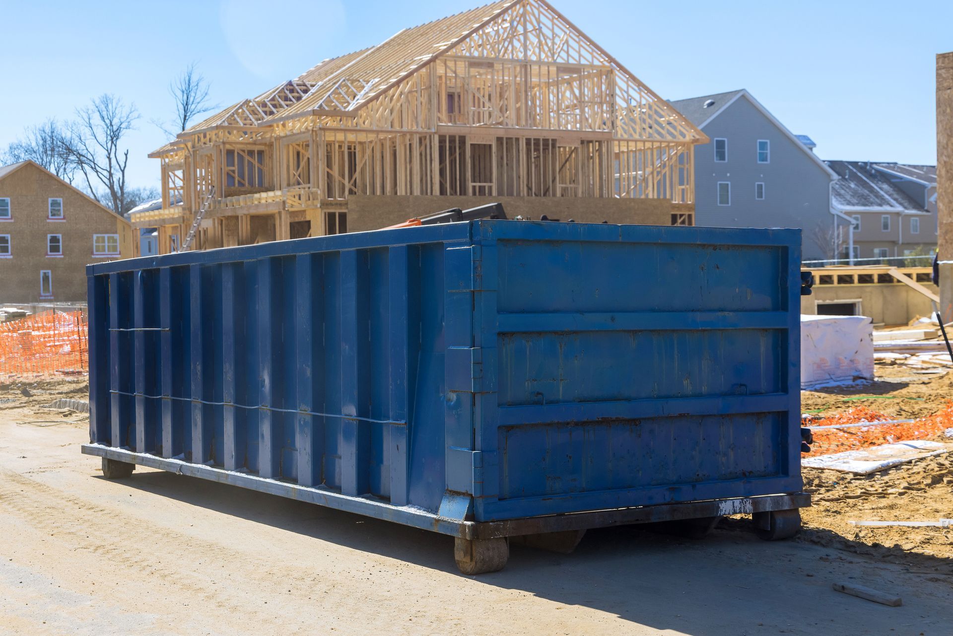 Home renovation site showcasing a rolloff dumpster loaded with debris near a construction area. Home renovation site showcasing a rolloff dumpster loaded with debris near a construction area.