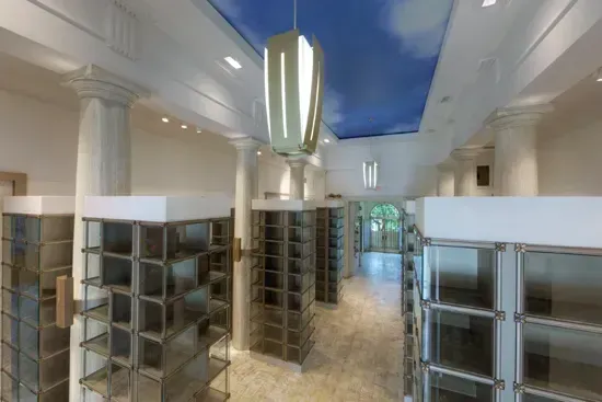 Spacious modern interior with tall columns and rows of glass-fronted display cabinets.