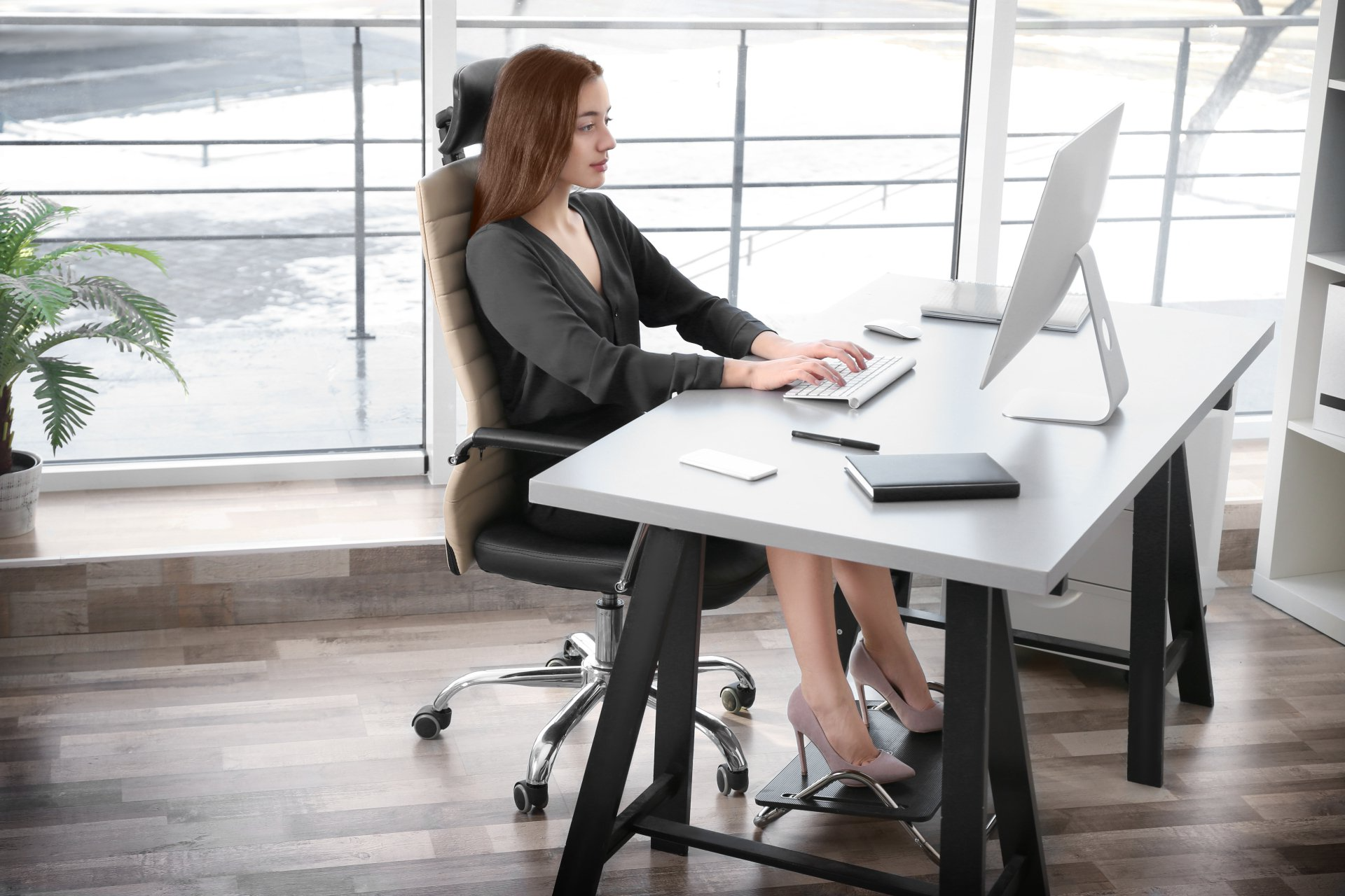 Une femme est assise à un bureau devant un ordinateur.