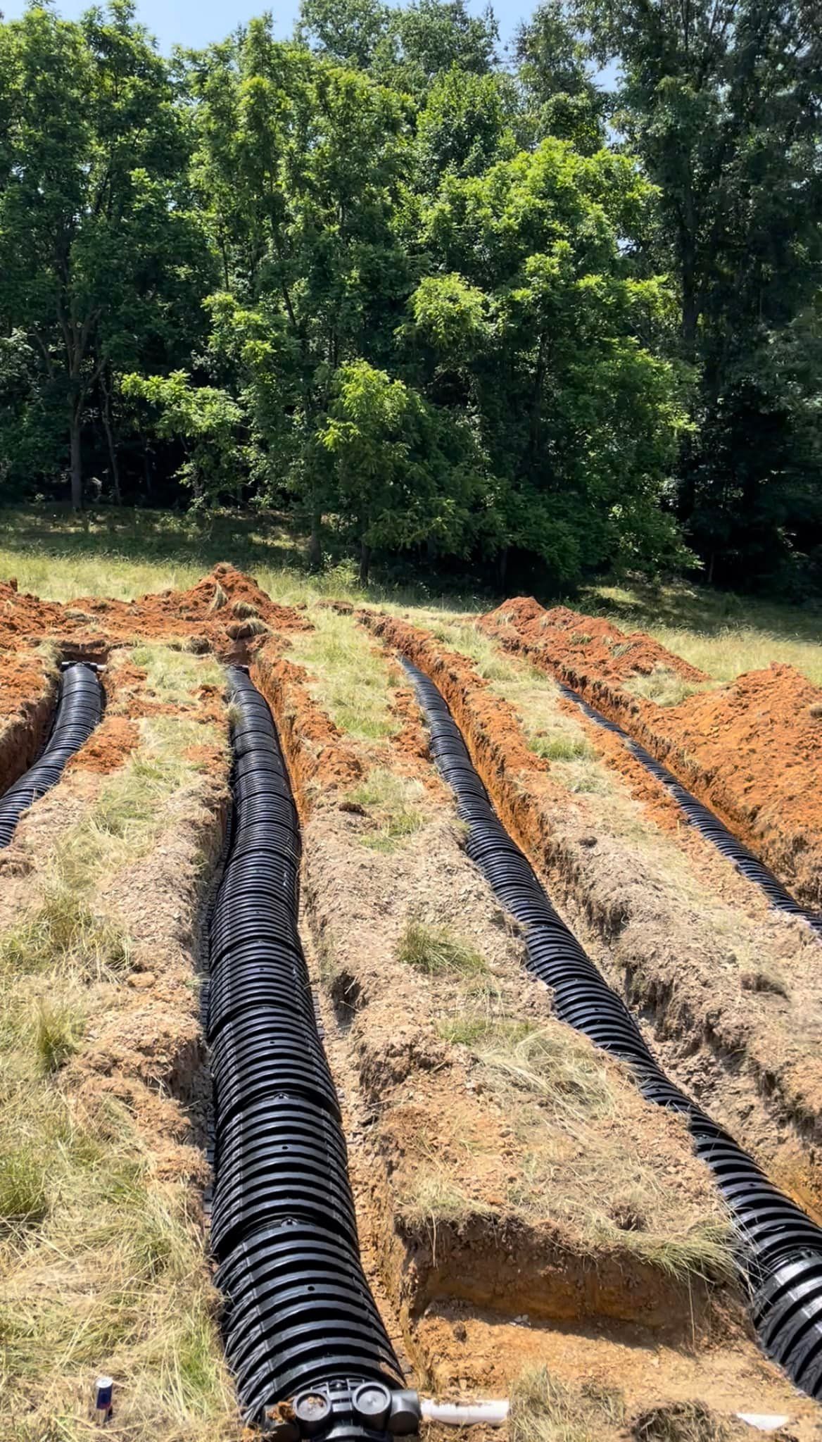 septic tanks are being installed in a field with trees in the background septic tanks are being installed in a field with trees in the background