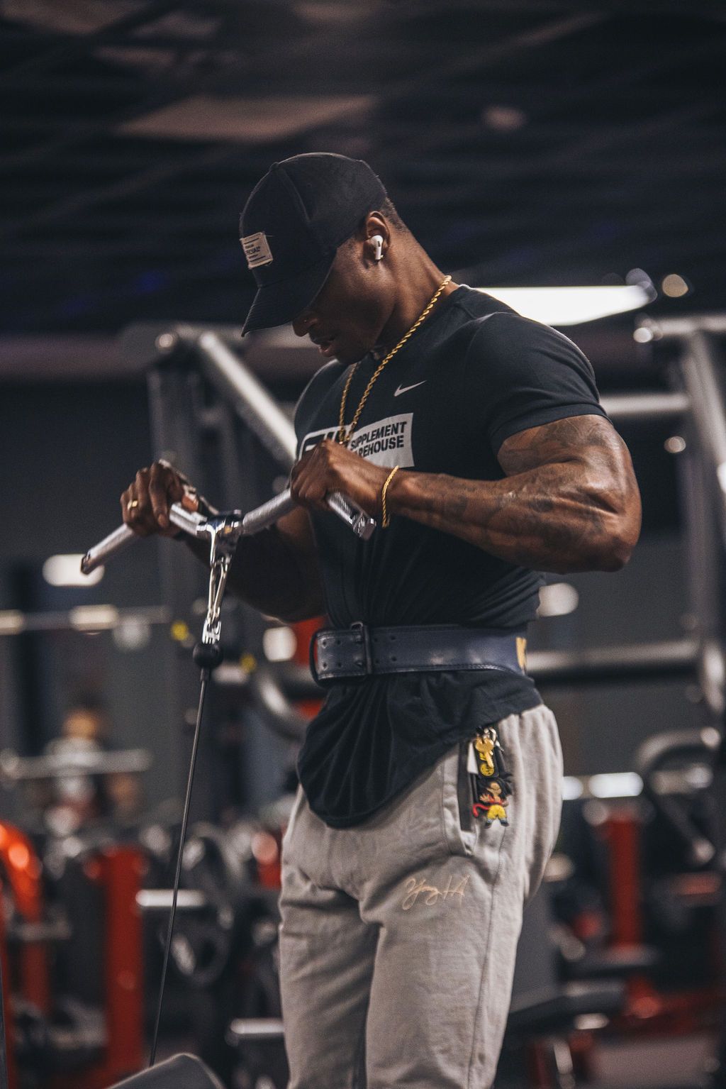 A man is lifting a barbell in a gym.