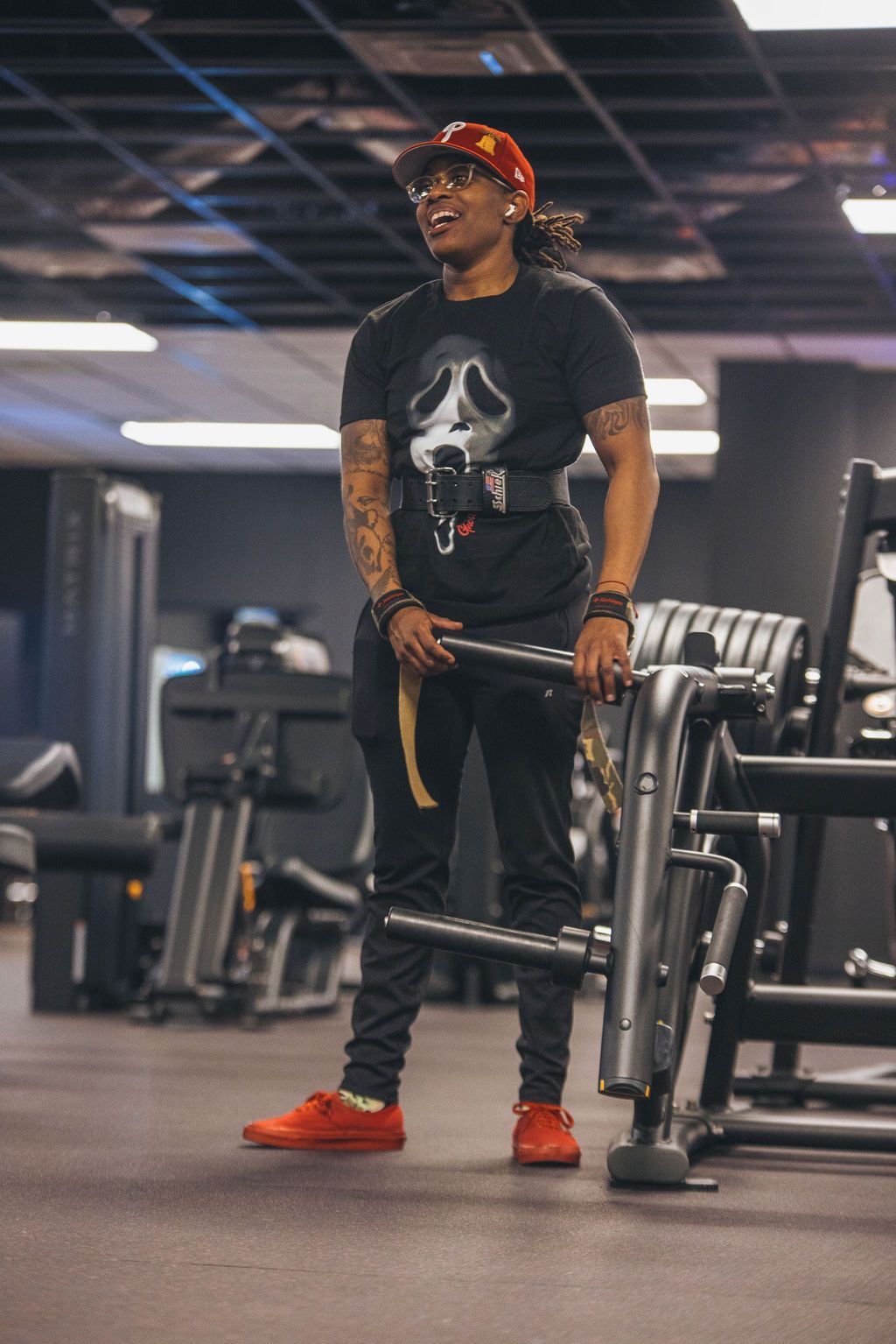 A man is standing in a gym holding a barbell.
