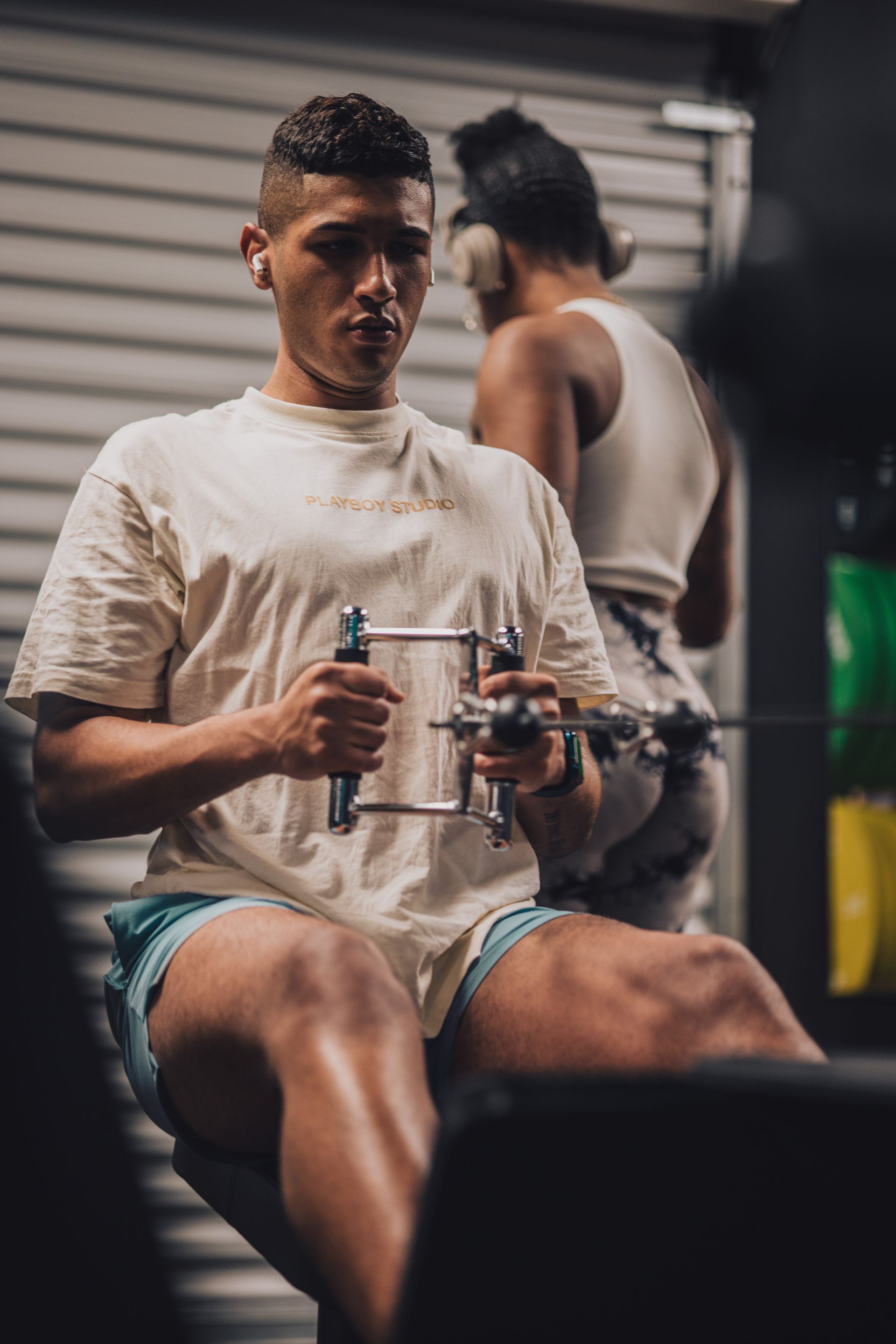 A man is sitting on a rowing machine in a gym.