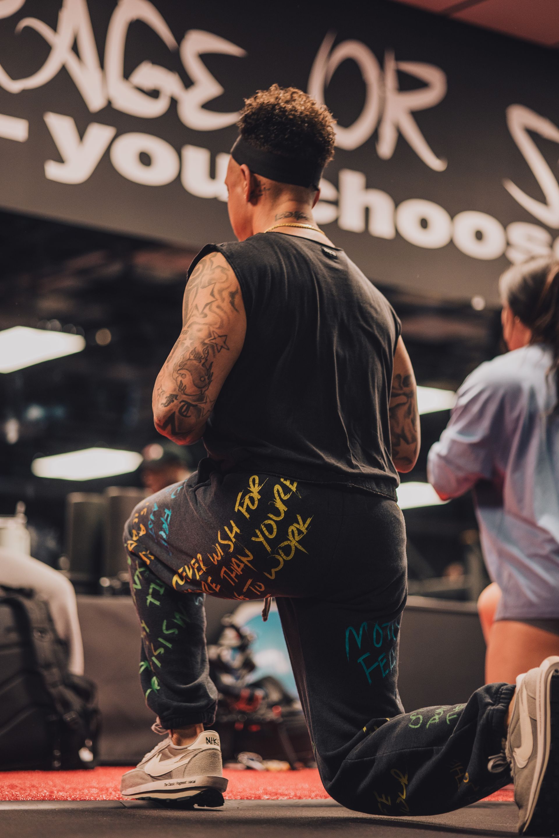 A man is kneeling down in front of a sign that says age or you choose.
