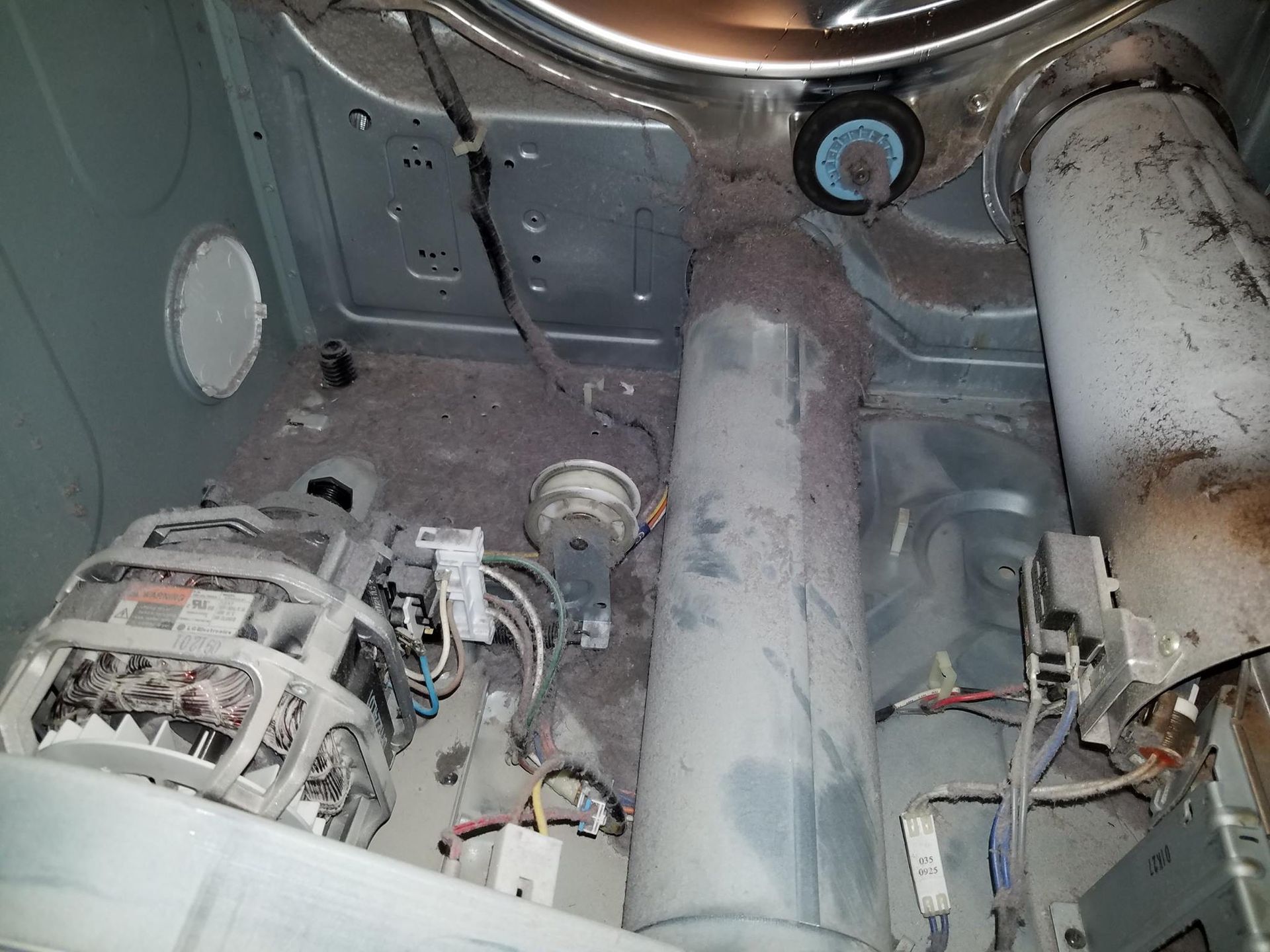 Inside a vehicle, view of metal chassis components and cylindrical tanks under the floor