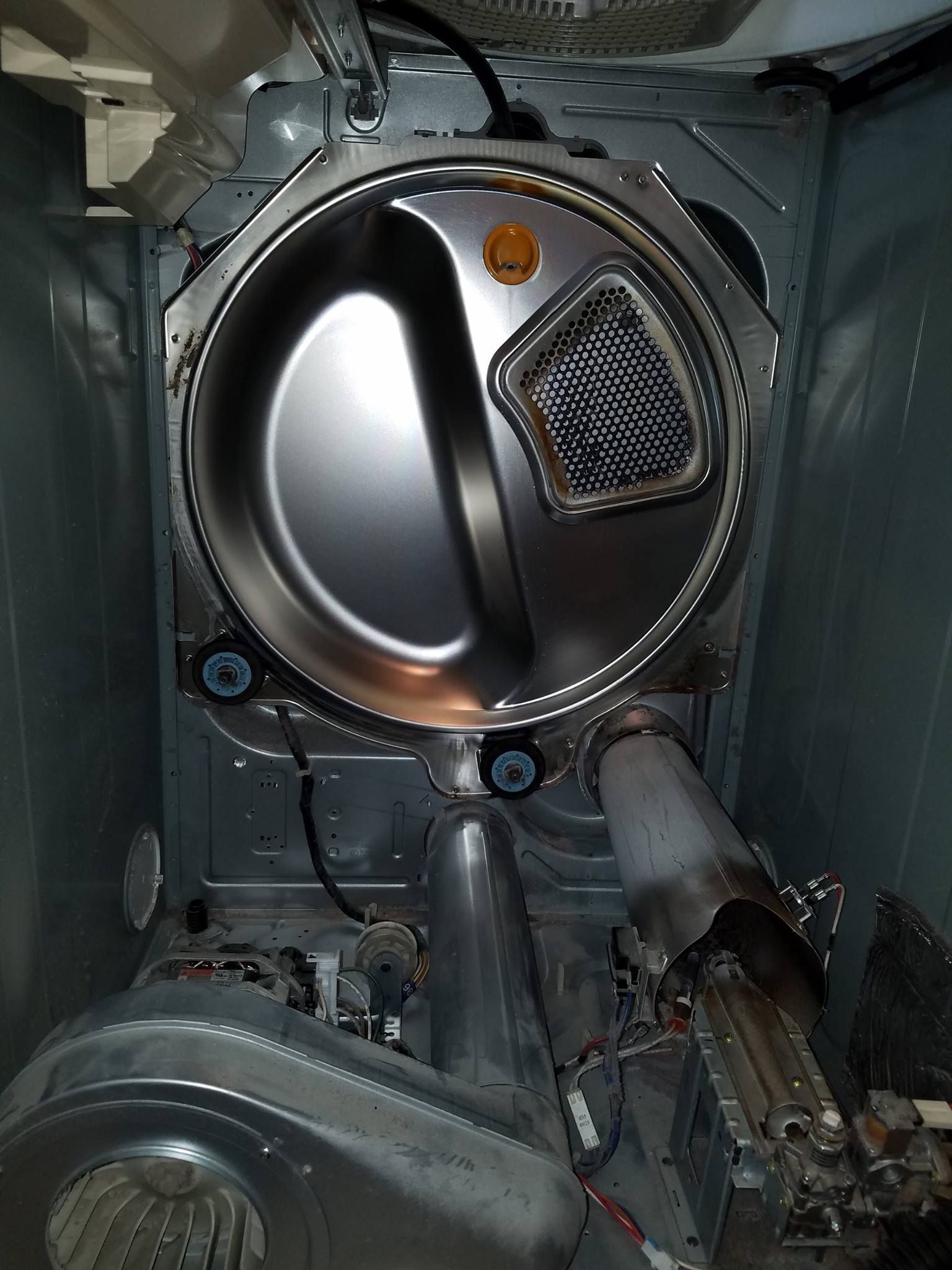 Close-up of a metallic machine interior with circular vents, pipes, and wiring.