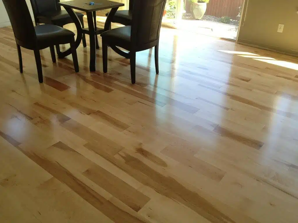 A wooden floor with a table and chairs on it