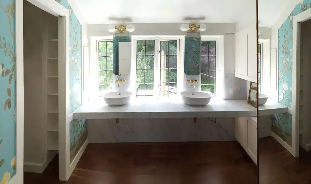 A bathroom with two sinks and a large mirror.
