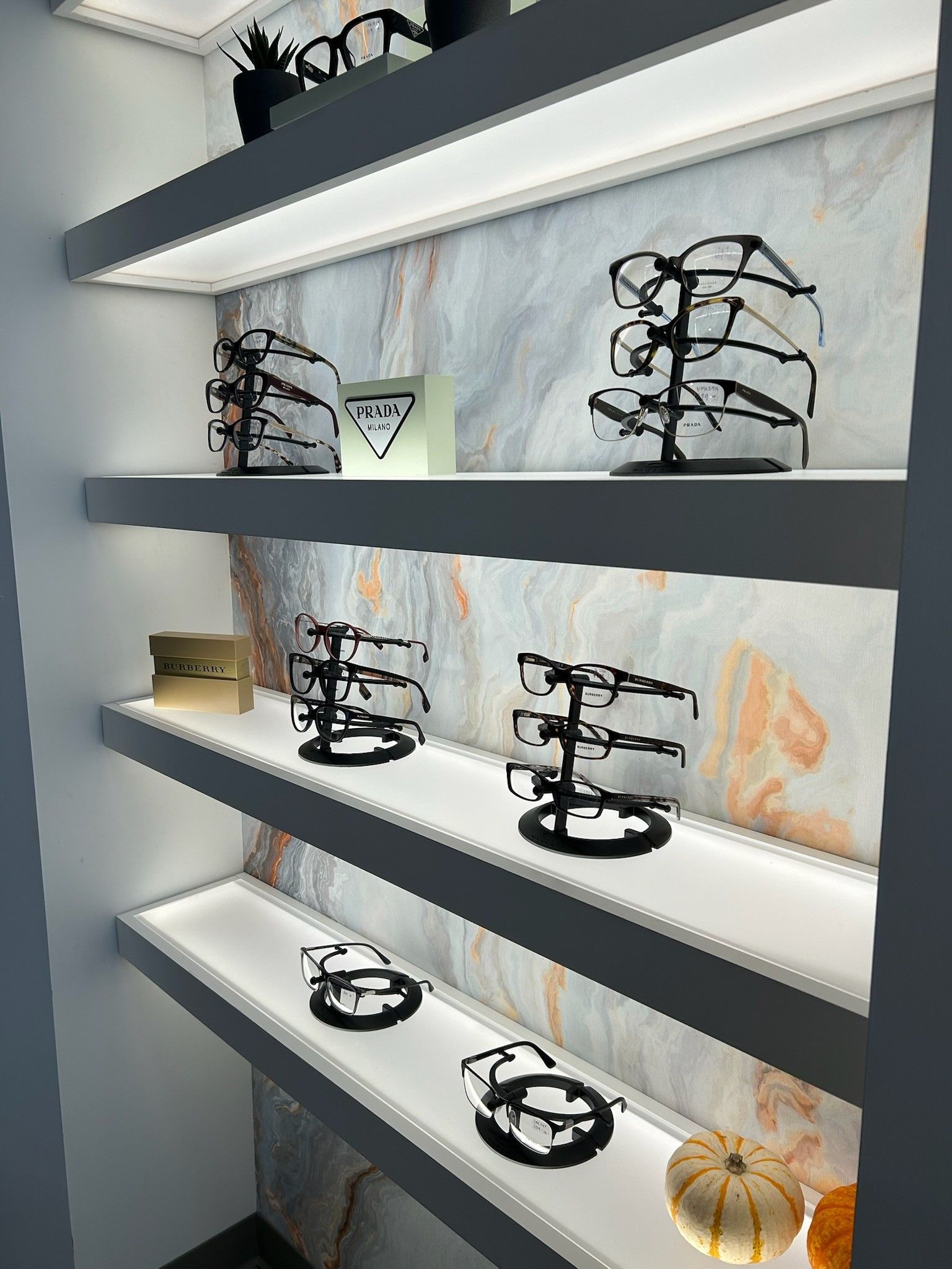 A row of shelves filled with glasses and a pumpkin.