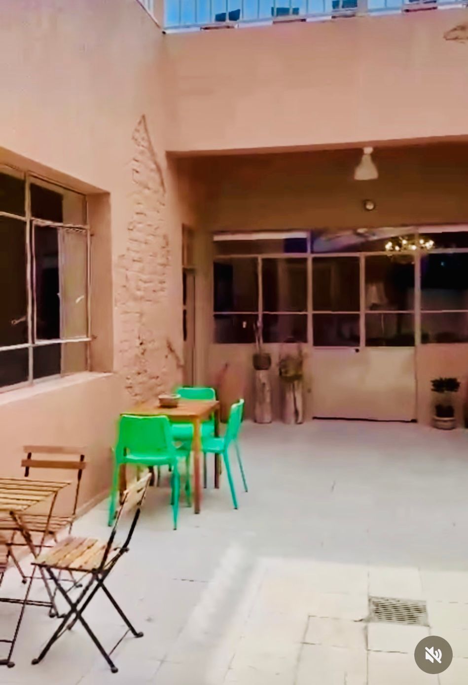 Un patio con mesas y sillas y el número 84 en la esquina.