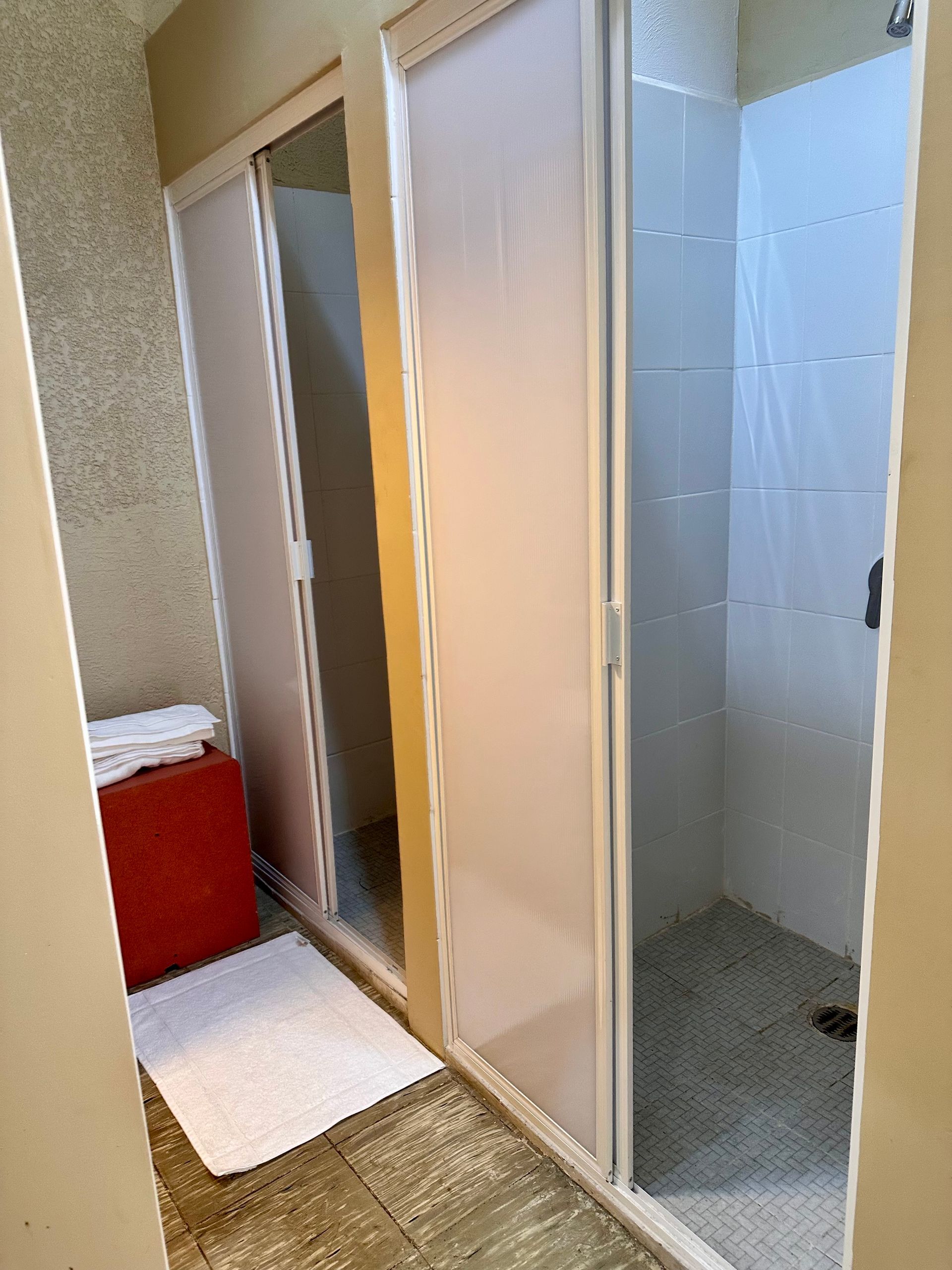 Un baño con puertas corredizas de vidrio y cabina de ducha.