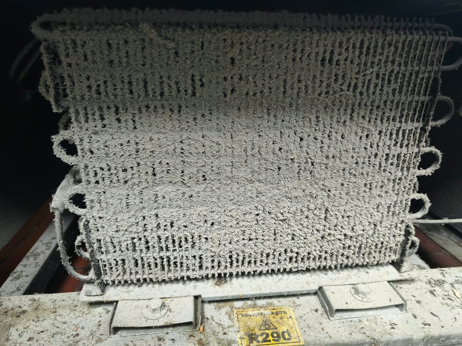 Cesta o recipiente pequeño de malla metálica con asas, que se muestra de frente sobre una superficie.