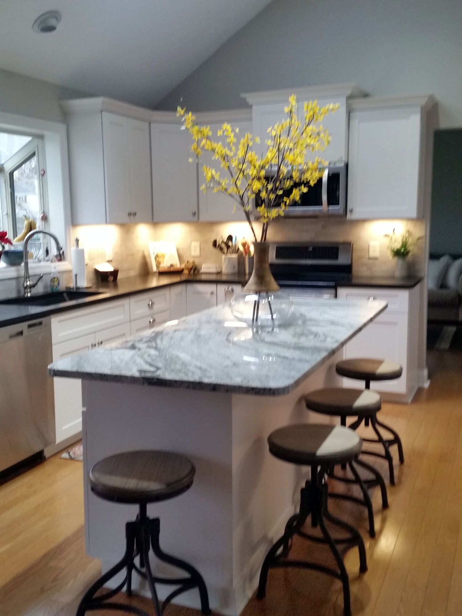a kitchen with a large island and stools Amish Cabinets custom.